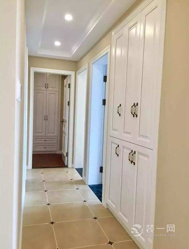 暖黄色的墙面,搭配白色的顶面及白色的壁柜,以及带角花的米黄色砖